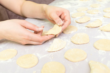 Woman's hands make ravioli