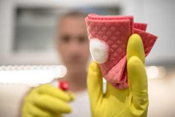 Man cleaning kitchen with spray and rag