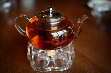 Glass infuser teapot with tea on the trivet