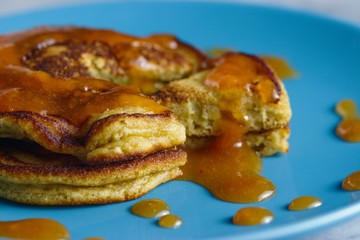 Homemade gluten free pancakes with peach jam served on sky blue plate. Close up shot