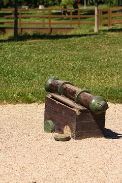 Old and worn wooden outdoor toy ship cannon in a playground in a park