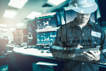 Double exposure of  Engineer or Technician man in working shirt  working with tablet in control...