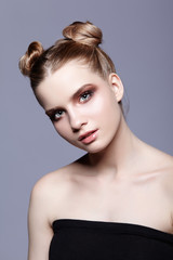 Young teen female beauty portrait with day makeup and bun hair style