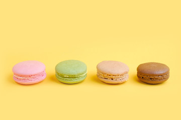 Varieties french macaroons biscuit with yellow background