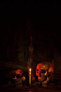 Two skull still life with knife in dark scene for halloween night