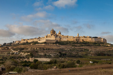 Fototapeta premium Ancient hilltop fortified by old capital city of Malta, The Silent City, Mdina or Rabat, skyline at sunrise.
