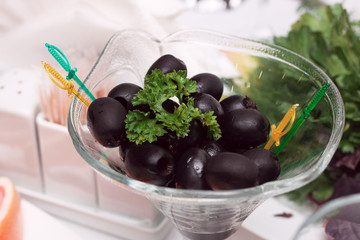 Spanish olives in a glass pial on a white table