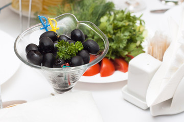 Spanish olives in a glass pial on a white table