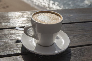 Cup of coffee on sea background