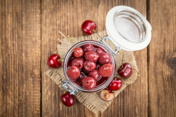 Portion of Canned Cherries on wooden background, selective focus