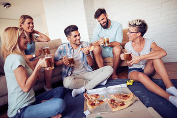 Happy friends eating pizza at home
