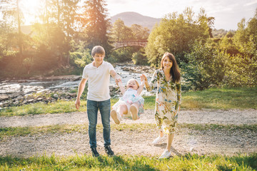 Fototapeta premium young family plaing with her daughter in mountains