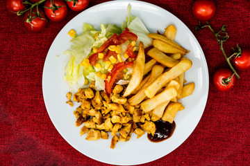 Fresh chicken with tomatoes and french fries