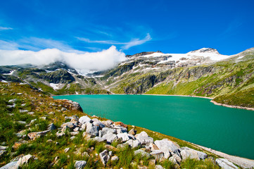 alps landscape - glacial lake in front of mountains and blue sky