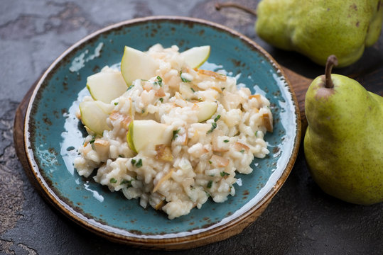 Risotto with pears on a turquoise plate, selective focus, studio shot
