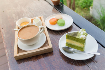 hot coffee breakfast set with green tea cake and fresh .macaroon in cozy outdoor cafe