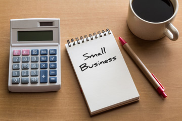 Small business, business concept - handwriting on notepad with cup of coffee and calculator