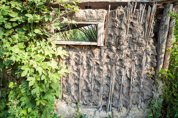 The old and collapsing wall of a house made of clay