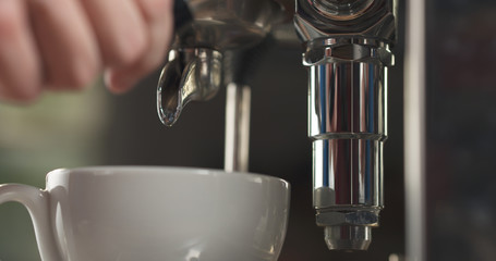 coffee pour from professional coffee machine into cappuccino cup
