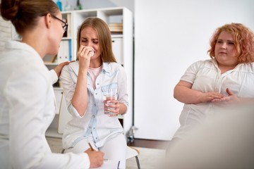 Obraz premium Young Woman Crying Hysterically in Group Therapy