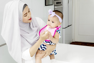 Muslim mother is feeding her cute baby