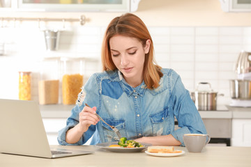 Obraz na płótnie Canvas Young woman having breakfast in light kitchen