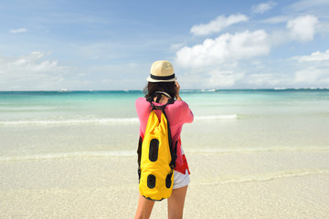 Young asian woman take picture using smartphone at beach
