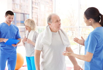 Fototapeta premium Physiotherapists with elderly patients in modern clinic