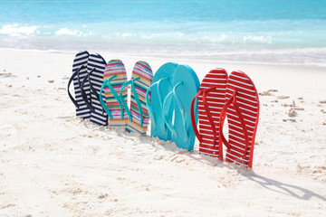Colorful flip-flops on sea shore. Summer vacation concept