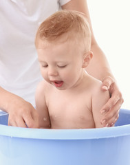 Mother bathing baby at home