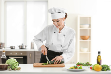 Young female chef cooking in kitchen