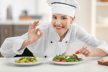 Young female chef with tasty dishes in kitchen