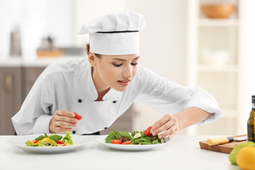 Young female chef with tasty dishes in kitchen