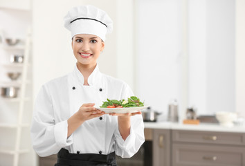 Young female chef with tasty dish in kitchen