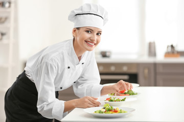 Young female chef cooking in kitchen
