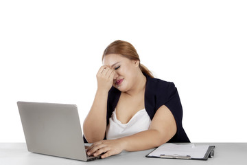 Stressful overweight woman works with laptop