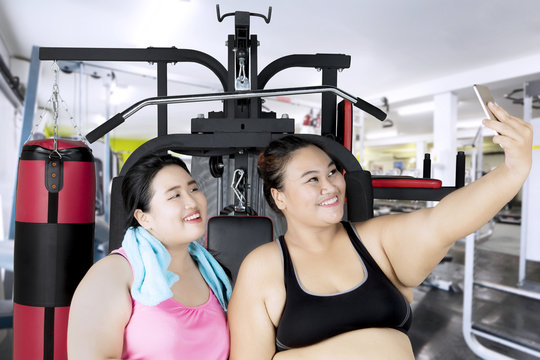 Fat women taking selfie in the fitness center