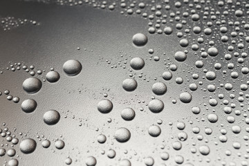 Water drops on a silvery surface