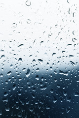 Raindrops on glass, blue background