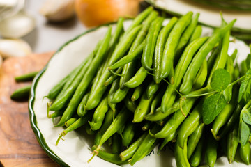 Fresh green snap beans on the plate ready to cook