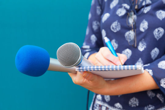 Female journalist taking notes at press conference