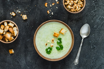 Green healthy cream soup with  broccoli, crackers, cashew, parsley. Top view