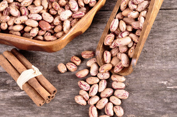 Colored beans in a wooden bowl on an old wooden background