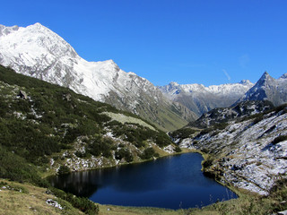Fototapeta na wymiar Galtür schneebedecktes Gebirge mit Bergsee, Zeinis see