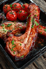 Pork middle chop roast with sweet and sour souce, baked tomatoes and red onion