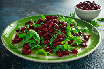 Red beans and wild rocket healthy salad in a green plate