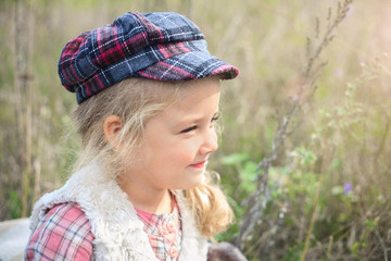 Portrait of a cute cheerful little girl on a nature.