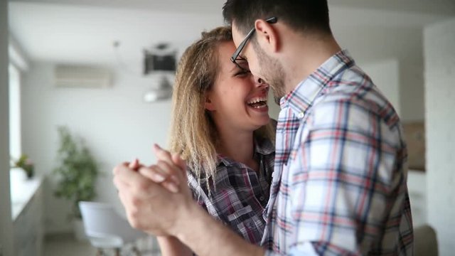 Woman having fun dancing with her husband at home smiling
