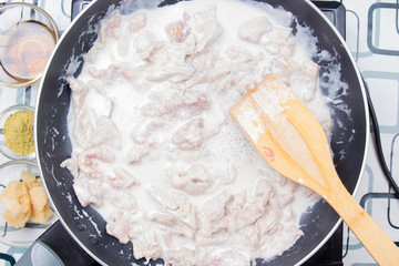 Chef stiring slice of beef with coconut milk