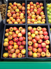 Many fruits red yellow apples lying in boxes in supermarket